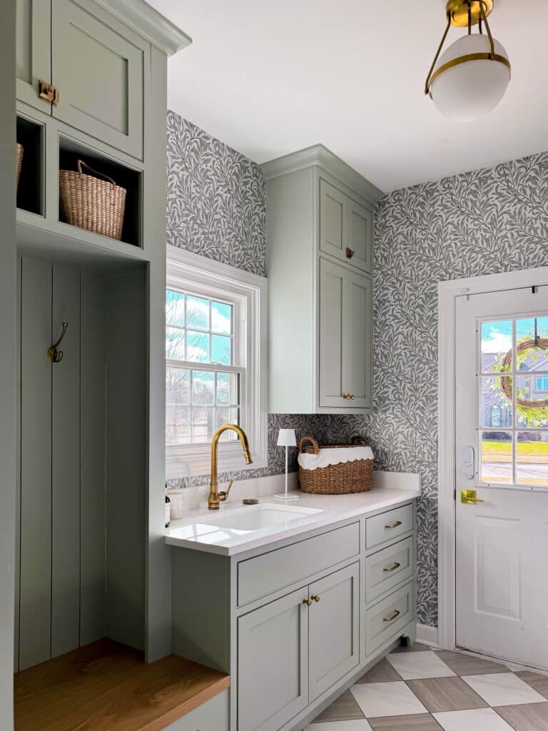 Green laundry room with checkered floor and botanical print wallpaper, laundry room ideas with stacked washer and dryer, laundry room ideas stacked, remodeled laundry room, Checkered floor tile, checkered floor, ceramic checkered floor, inset cabinets, green cabinetry, sherwin williams comfort gray